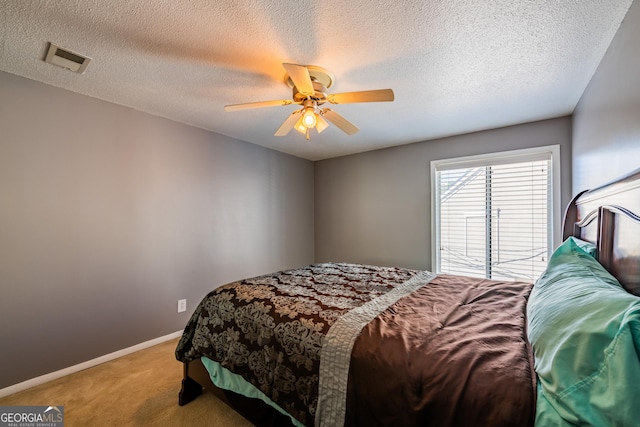 carpeted bedroom with a textured ceiling and ceiling fan