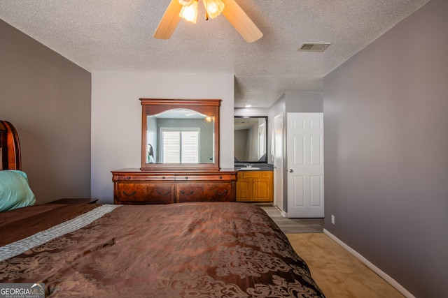 bedroom featuring ceiling fan, a textured ceiling, and light carpet