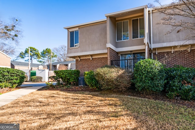 view of side of home with a lawn and central AC