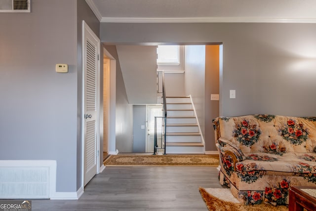 stairway with hardwood / wood-style floors and crown molding