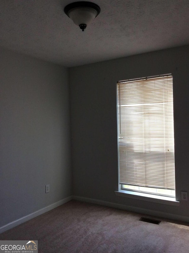 unfurnished room featuring carpet