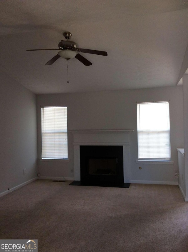 unfurnished living room featuring ceiling fan and carpet