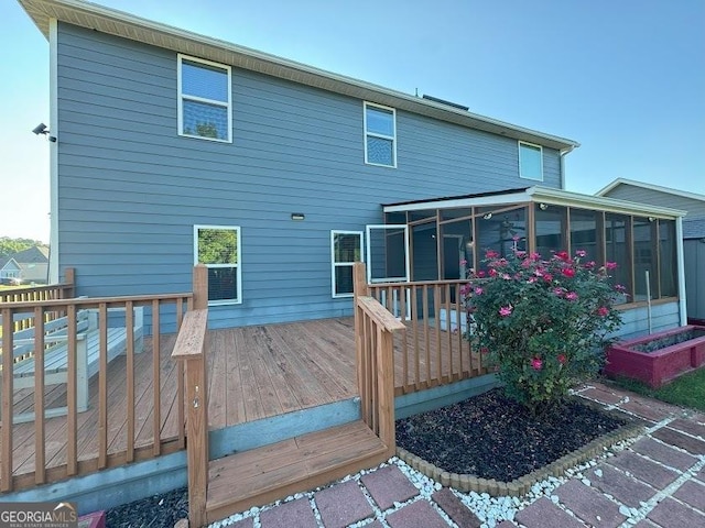 rear view of house with a wooden deck and a sunroom