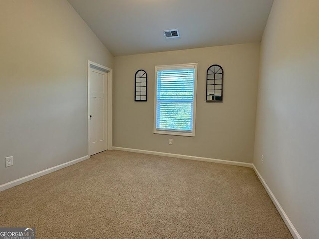 unfurnished room with carpet flooring and lofted ceiling