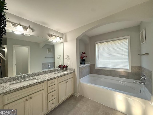 bathroom with tile patterned floors, vanity, and a tub to relax in