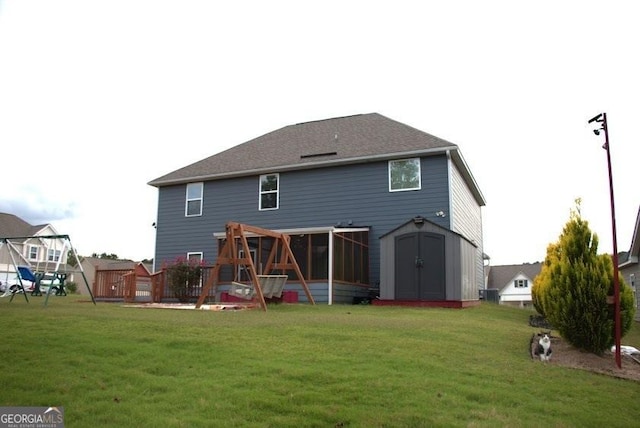 back of property with a deck, a storage unit, and a lawn