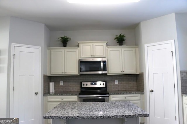 kitchen with decorative backsplash, light stone countertops, and stainless steel appliances