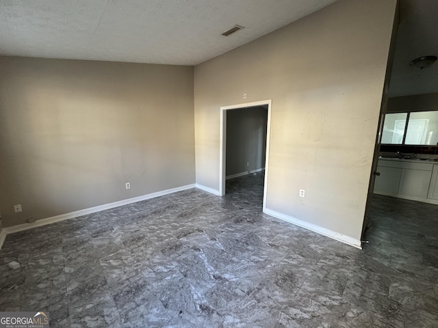 unfurnished room with a textured ceiling