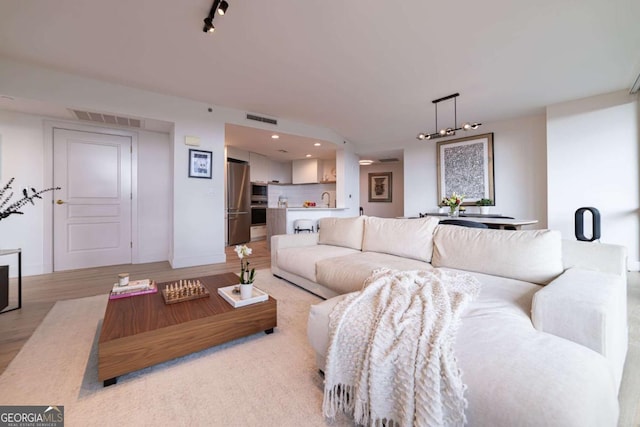 living room with sink and light hardwood / wood-style floors