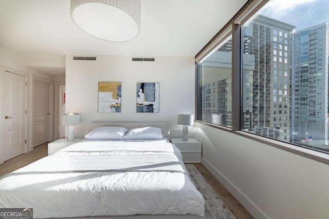 bedroom with light wood-type flooring and multiple windows