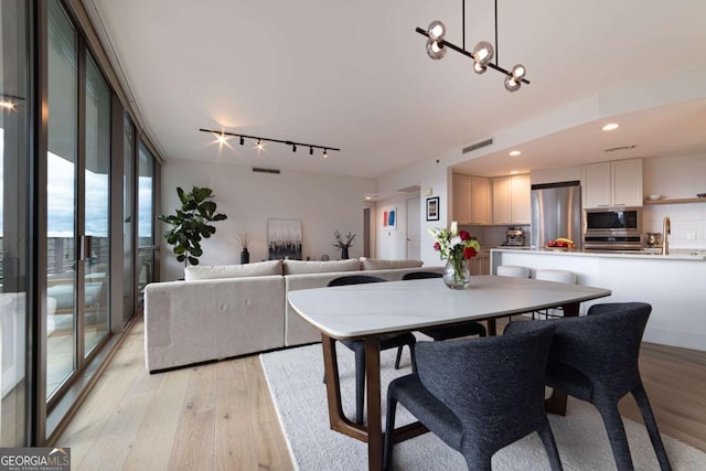 dining room with a chandelier and light wood-type flooring