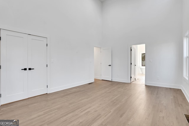 interior space with a towering ceiling and light wood-type flooring