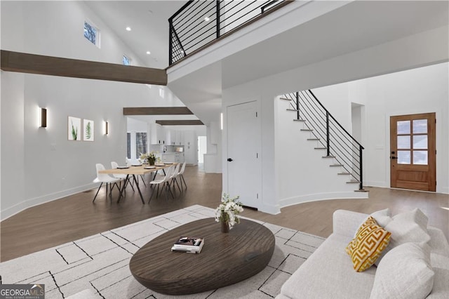 living room with a towering ceiling and light hardwood / wood-style floors