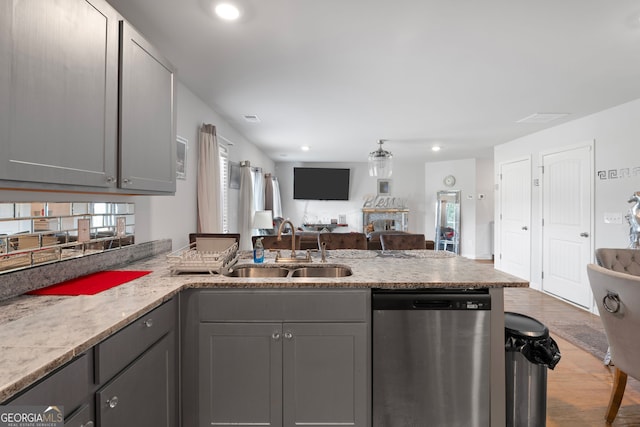 kitchen featuring gray cabinetry, light stone countertops, sink, and stainless steel dishwasher