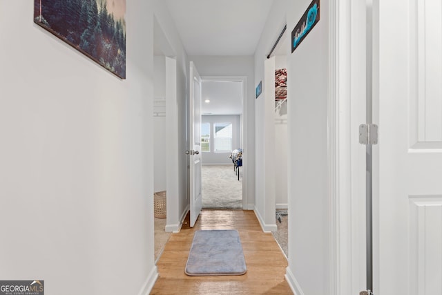 hallway with light hardwood / wood-style floors