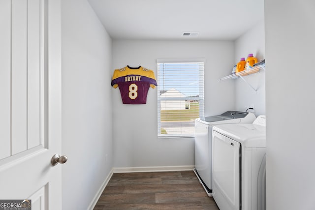 laundry area featuring washing machine and dryer, dark wood-type flooring, and a healthy amount of sunlight