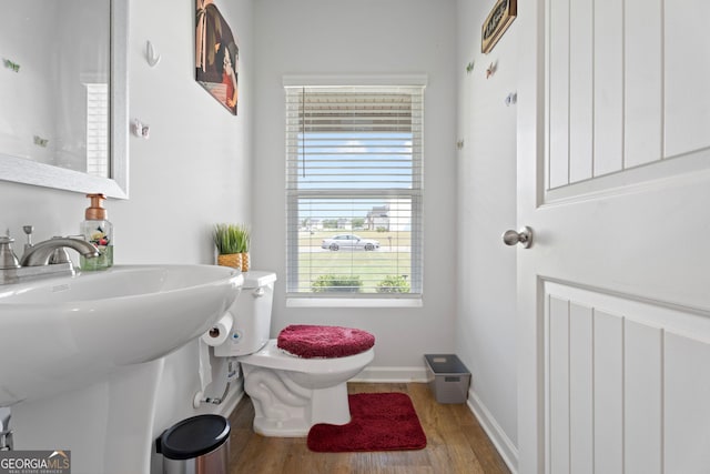 bathroom featuring wood-type flooring and toilet