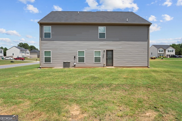 rear view of property with a yard