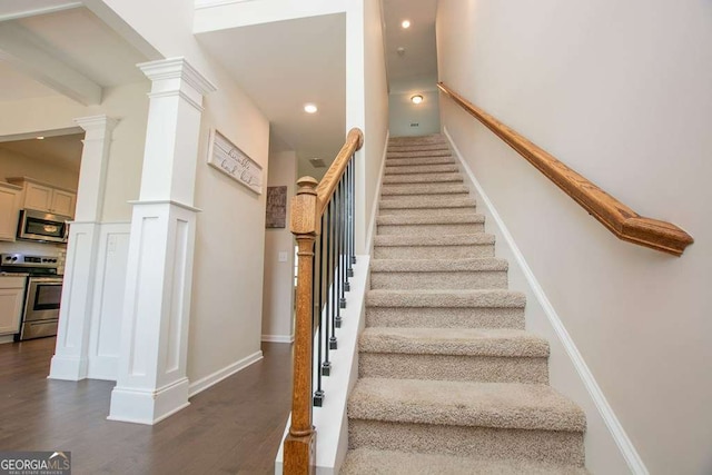 staircase with hardwood / wood-style floors and beamed ceiling