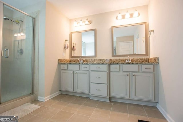 bathroom featuring tile patterned flooring, vanity, and a shower with shower door