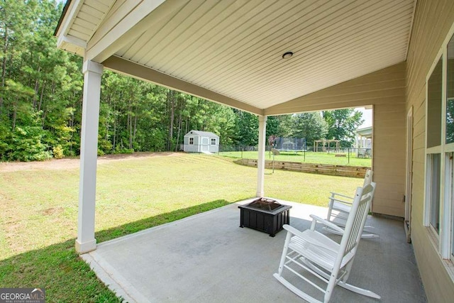 view of patio featuring a storage unit, a trampoline, and an outdoor fire pit