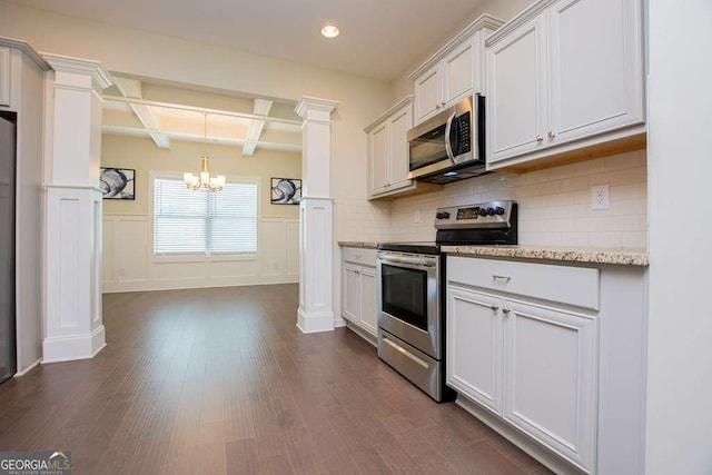 kitchen with stainless steel appliances, white cabinetry, and light stone counters