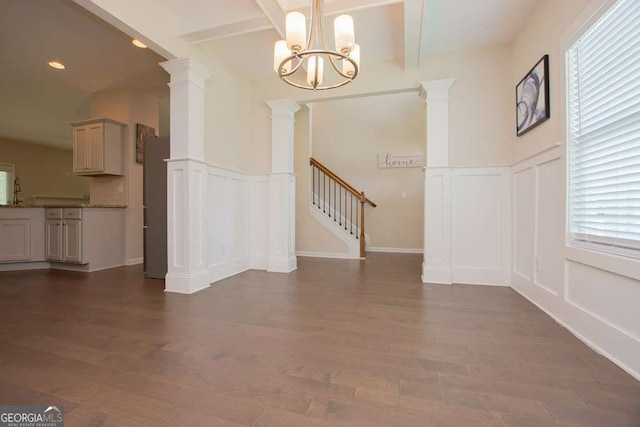 unfurnished living room with dark hardwood / wood-style flooring, beamed ceiling, and a chandelier