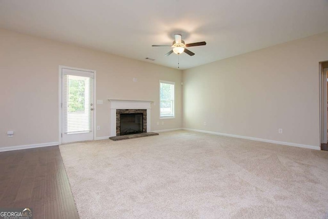 unfurnished living room with a fireplace, plenty of natural light, and ceiling fan