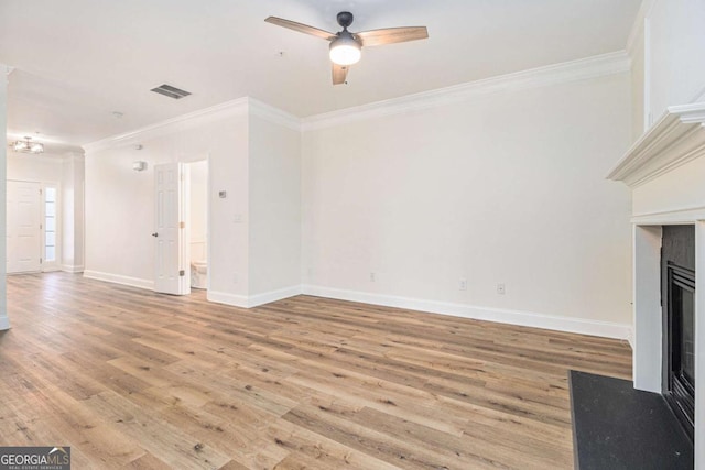 unfurnished living room featuring ceiling fan, ornamental molding, and light hardwood / wood-style flooring