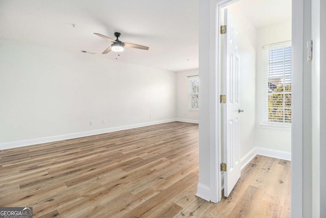 unfurnished room featuring ceiling fan, light hardwood / wood-style flooring, and a healthy amount of sunlight