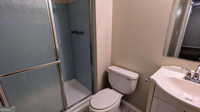 bathroom with tile patterned floors, a shower with door, vanity, and toilet