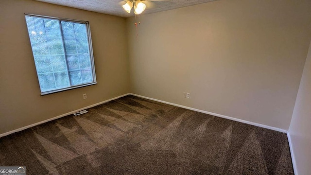 carpeted spare room featuring ceiling fan and a textured ceiling