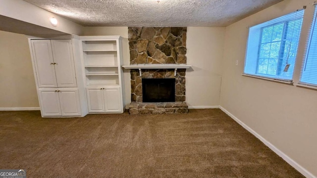 unfurnished living room featuring a stone fireplace, carpet, and a textured ceiling