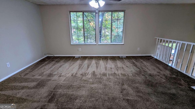 carpeted spare room featuring ceiling fan and a textured ceiling