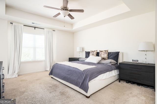 bedroom featuring carpet flooring, ceiling fan, and a tray ceiling