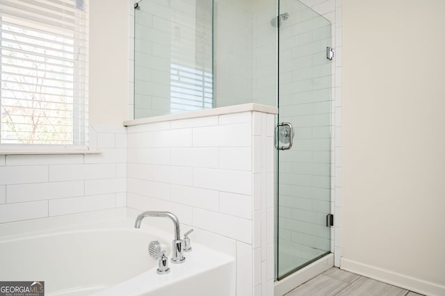 bathroom featuring shower with separate bathtub