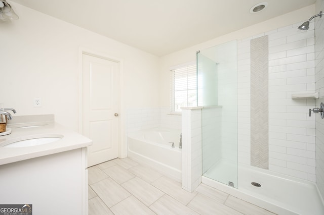 bathroom featuring tile patterned flooring, vanity, and shower with separate bathtub