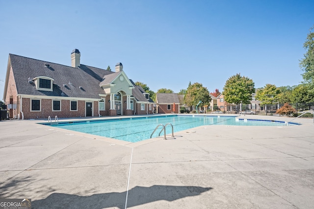 view of swimming pool featuring cooling unit and a patio