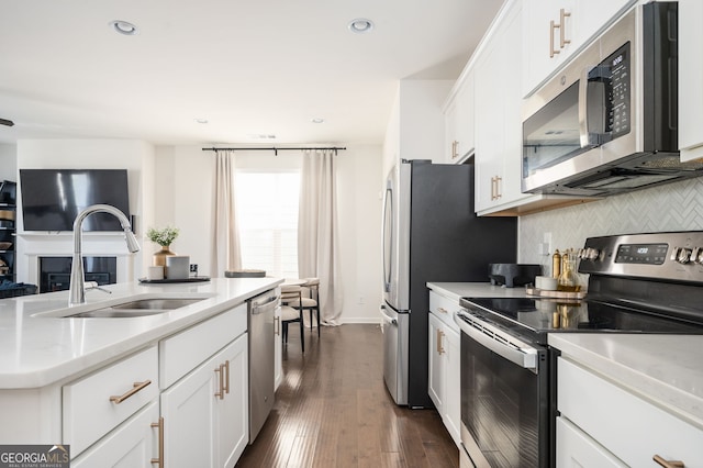 kitchen featuring dark wood-type flooring, white cabinets, sink, decorative backsplash, and stainless steel appliances