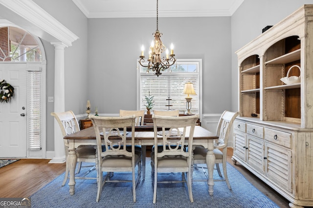 dining space with decorative columns, a wealth of natural light, crown molding, and dark hardwood / wood-style floors