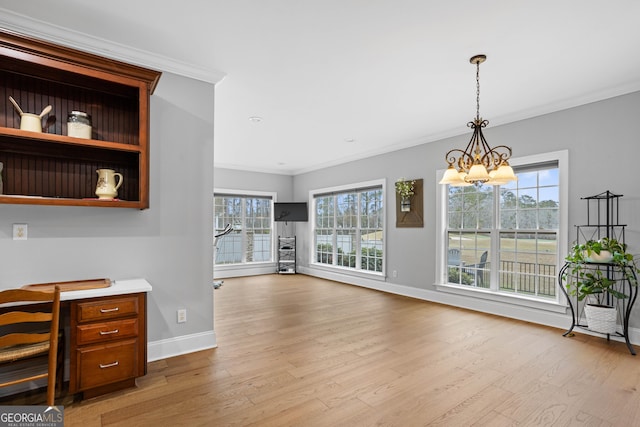 interior space with a healthy amount of sunlight, ornamental molding, and a chandelier