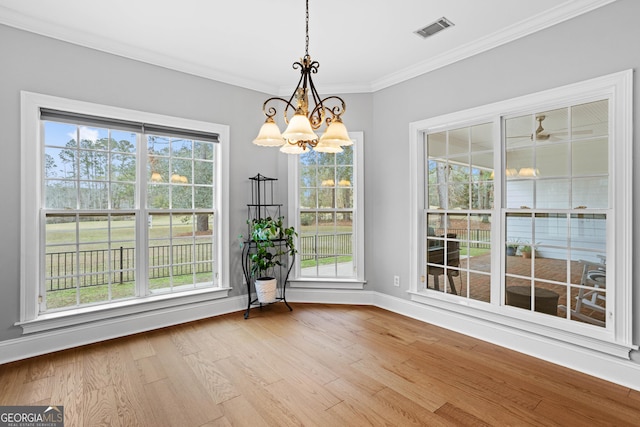 unfurnished dining area featuring light hardwood / wood-style floors, an inviting chandelier, and crown molding