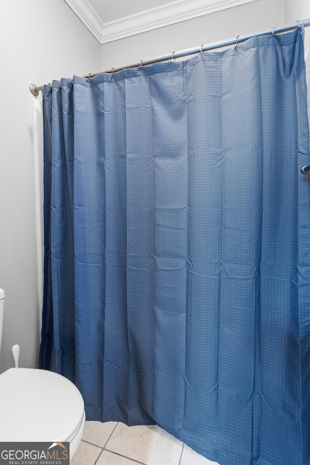 bathroom featuring tile patterned flooring, a shower with curtain, toilet, and crown molding