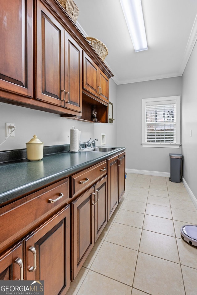 kitchen with ornamental molding, sink, and light tile patterned floors