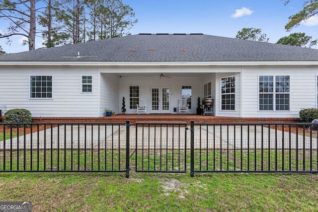 rear view of house featuring a lawn, ceiling fan, and french doors