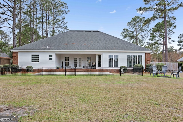 rear view of property featuring a lawn and french doors