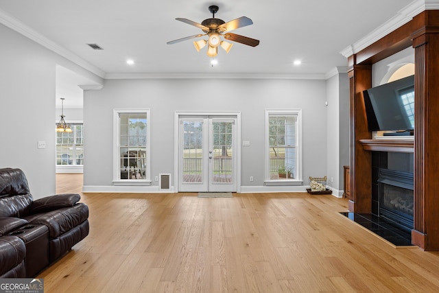 living room with plenty of natural light, light wood-type flooring, and crown molding