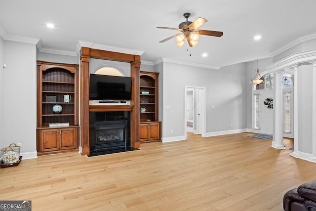 living room featuring ceiling fan, ornate columns, a fireplace, and light hardwood / wood-style flooring