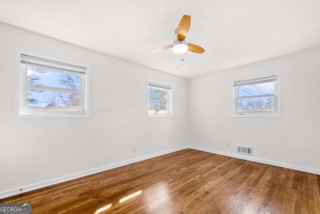 spare room with wood-type flooring, plenty of natural light, and ceiling fan