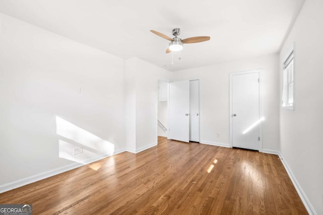 unfurnished bedroom with ceiling fan and wood-type flooring